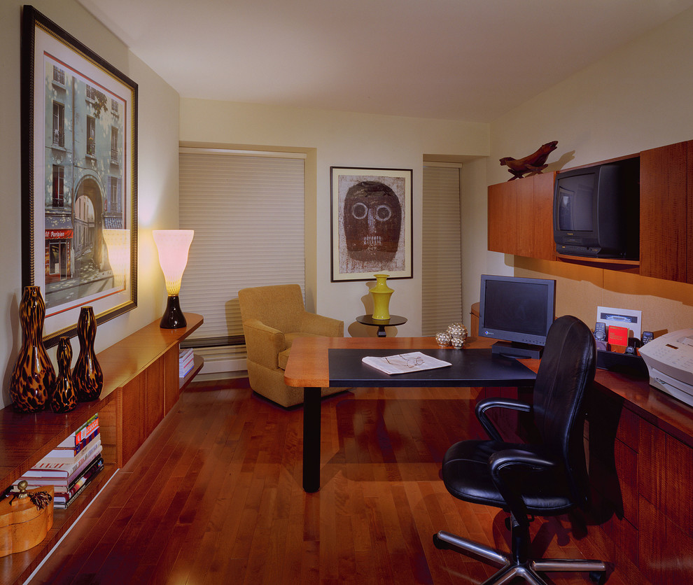 Ejemplo de despacho clásico renovado pequeño sin chimenea con biblioteca, paredes beige, suelo de madera oscura, escritorio empotrado y suelo marrón