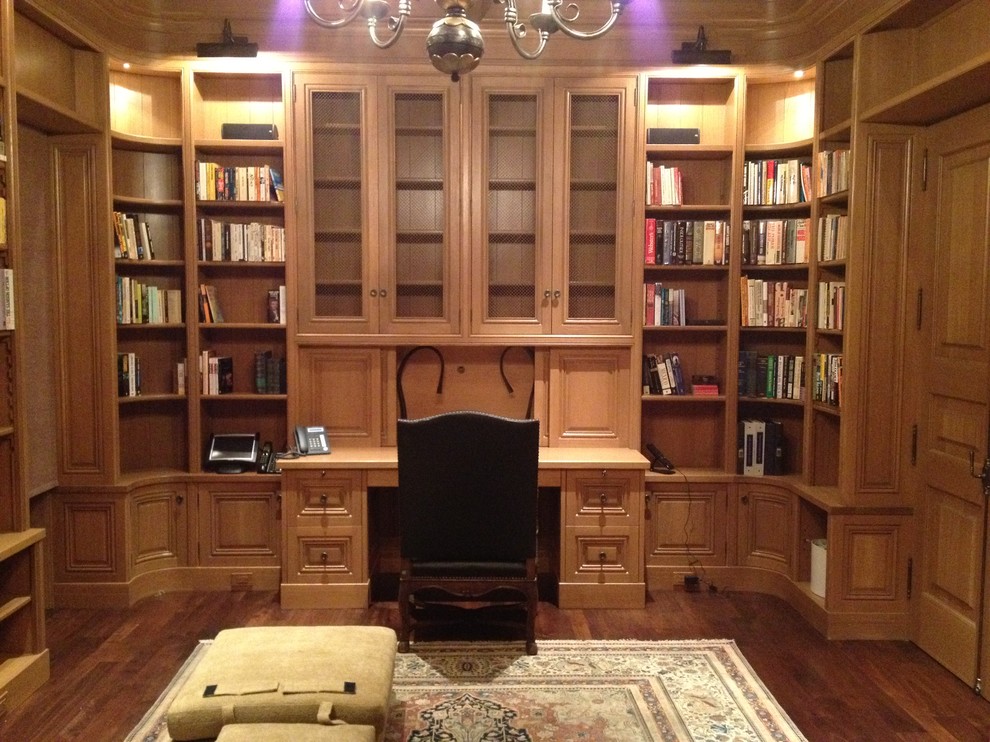 Modelo de despacho tradicional renovado grande con suelo de madera en tonos medios y escritorio empotrado
