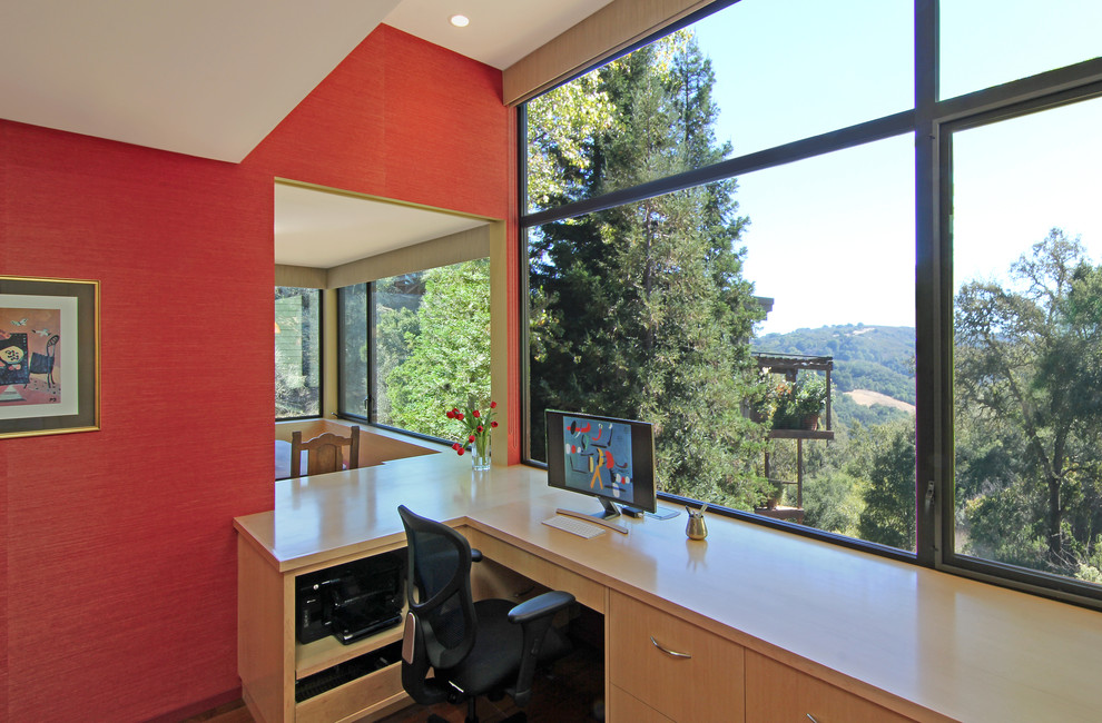 Diseño de despacho minimalista de tamaño medio sin chimenea con paredes rojas, suelo de madera en tonos medios y escritorio empotrado