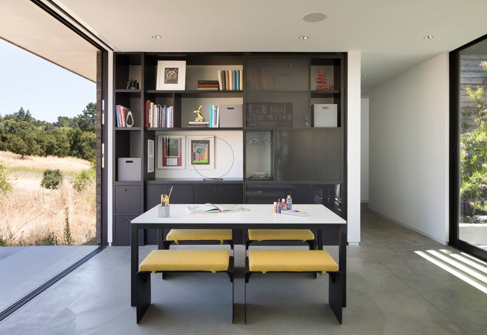 На фото: кабинет в современном стиле с местом для рукоделия, белыми стенами, бетонным полом, отдельно стоящим рабочим столом и серым полом