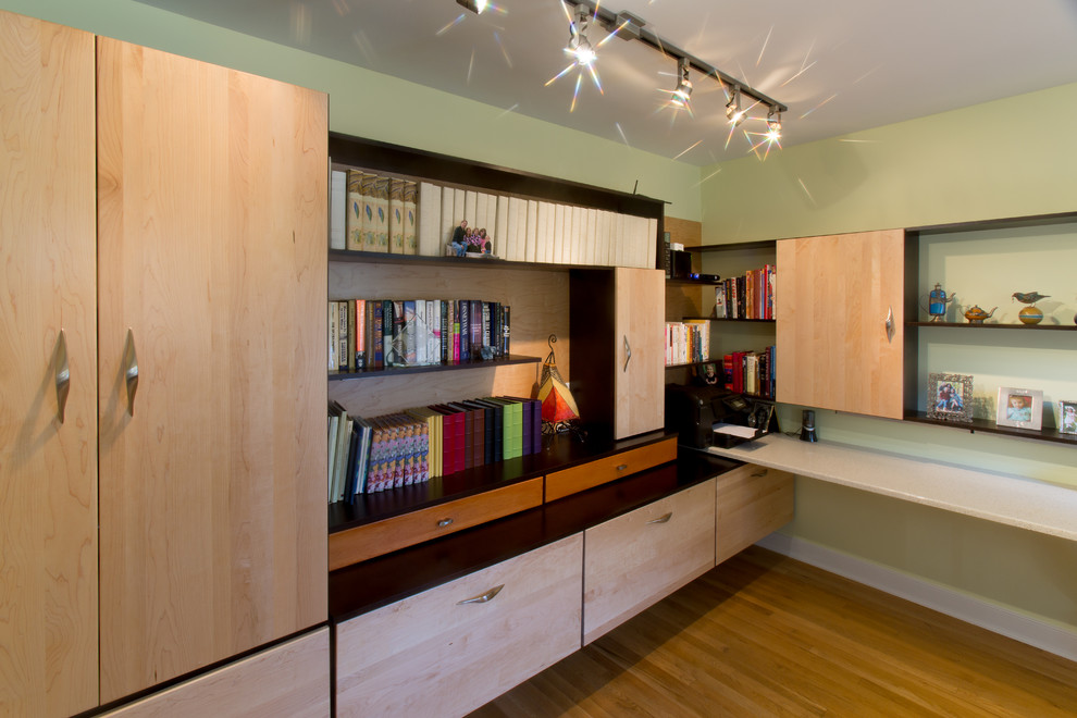 Esempio di un ufficio moderno di medie dimensioni con pareti verdi, pavimento in legno massello medio e scrivania incassata