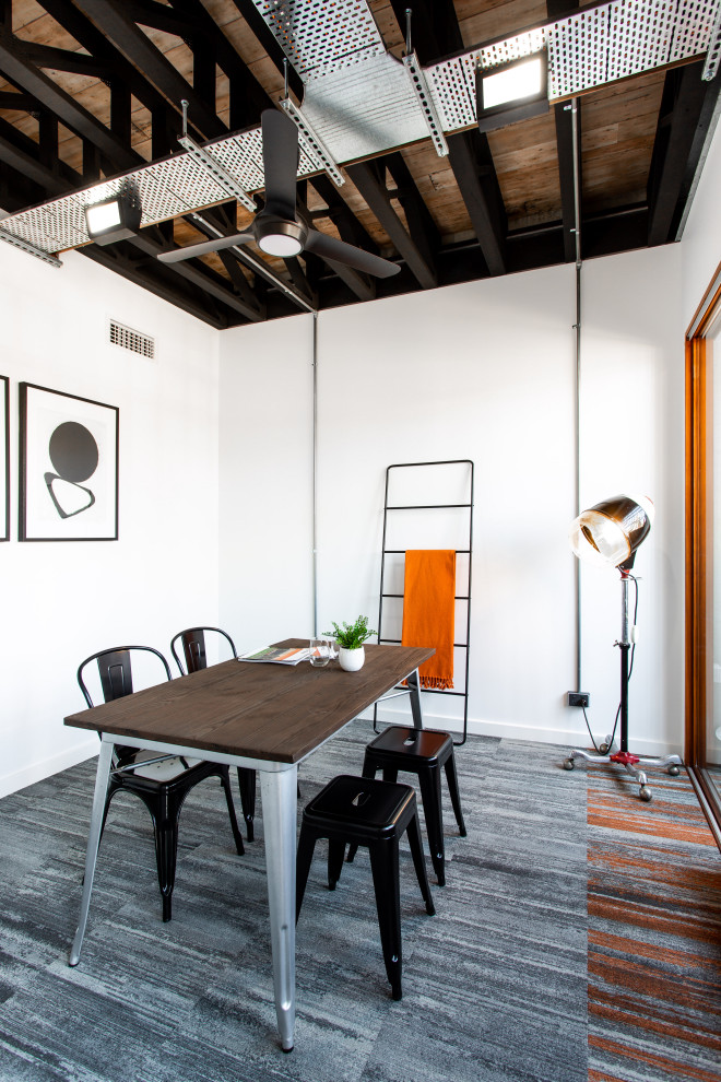 Идея дизайна: кабинет в стиле лофт с белыми стенами, ковровым покрытием, отдельно стоящим рабочим столом, серым полом и балками на потолке