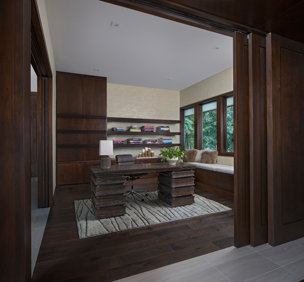 This is an example of a medium sized modern study in Detroit with green walls, dark hardwood flooring, a freestanding desk and brown floors.
