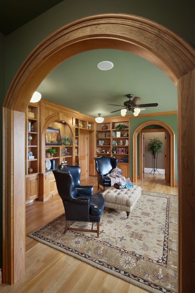 Großes Klassisches Lesezimmer mit grüner Wandfarbe, braunem Holzboden, Einbau-Schreibtisch und beigem Boden in Detroit