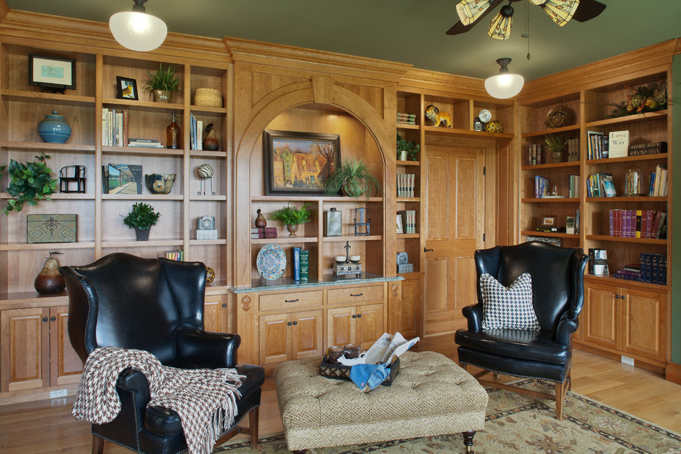 Ejemplo de despacho tradicional grande con biblioteca, paredes verdes, suelo de madera en tonos medios, escritorio empotrado y suelo beige
