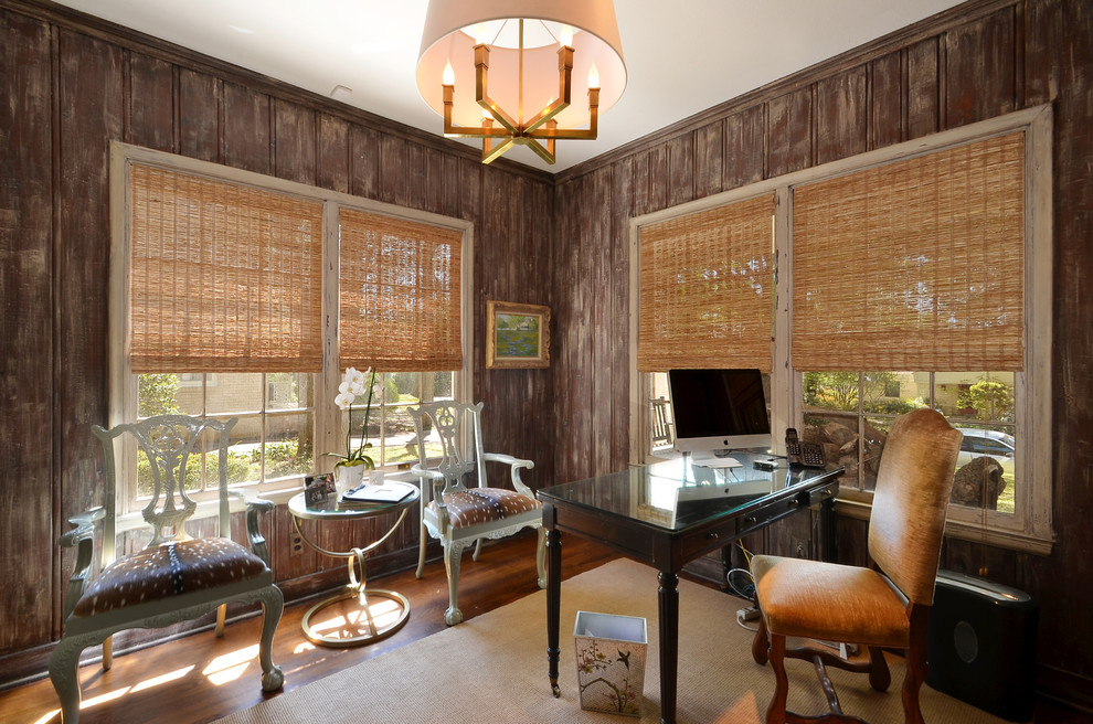 Mittelgroßes Klassisches Arbeitszimmer ohne Kamin mit dunklem Holzboden, freistehendem Schreibtisch und brauner Wandfarbe in Austin