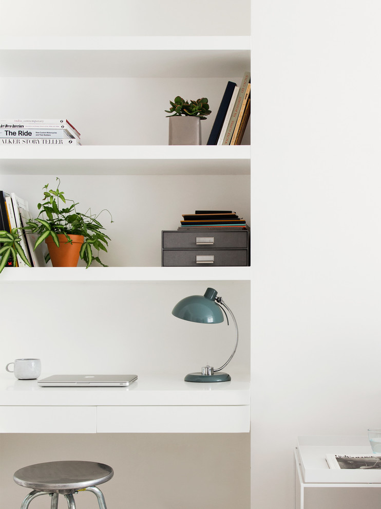 Study room - small scandinavian built-in desk light wood floor study room idea in London with white walls