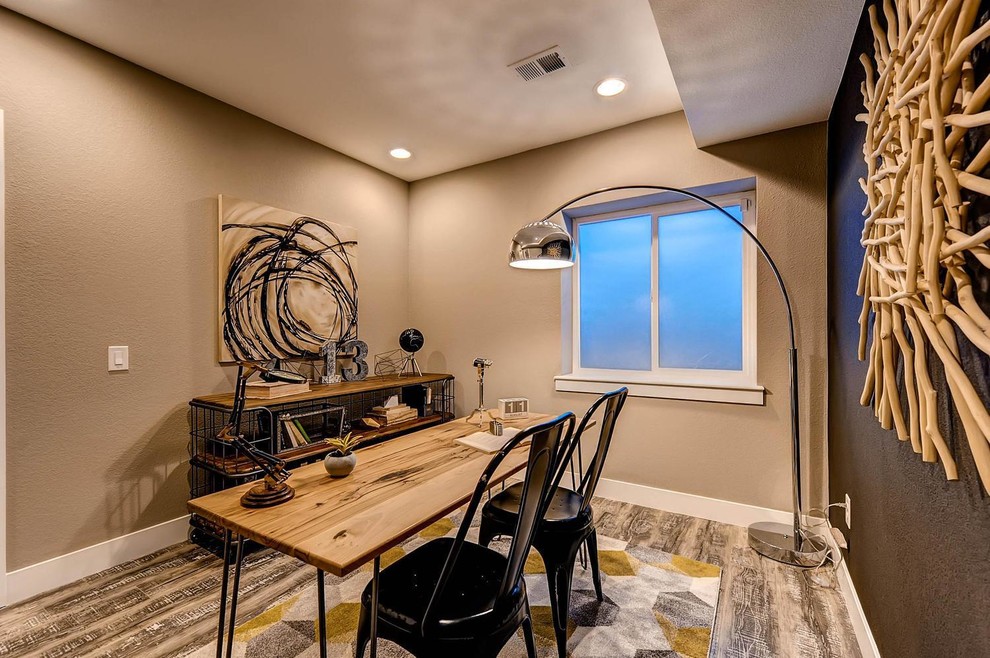 Foto de despacho de estilo americano de tamaño medio sin chimenea con paredes marrones, suelo laminado y escritorio independiente