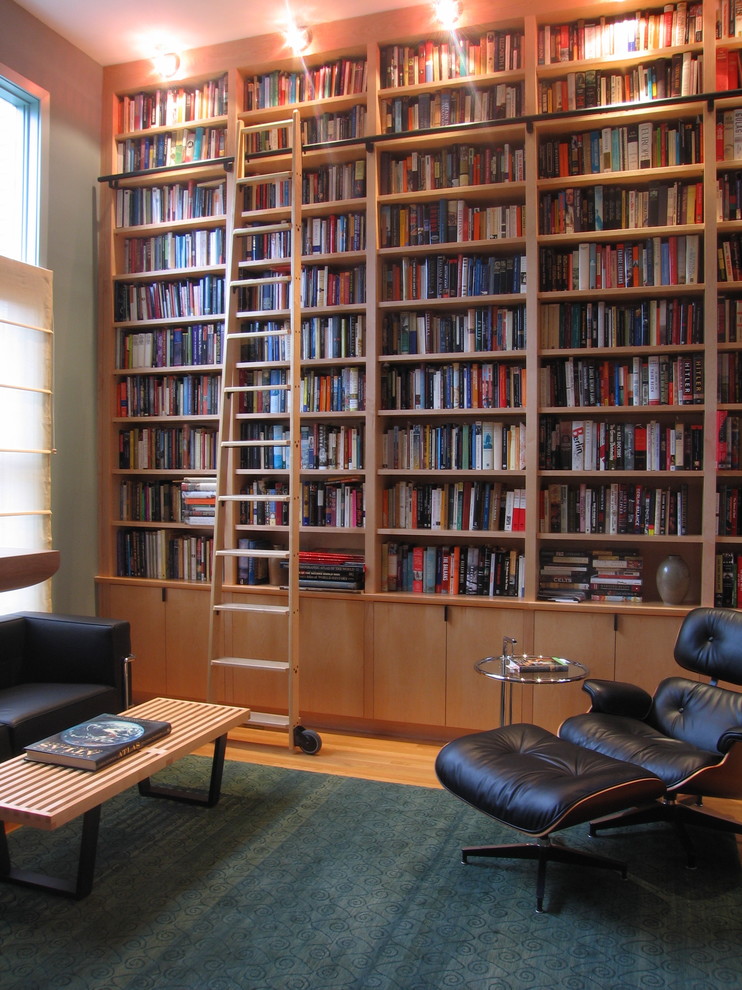 Cette image montre un bureau design de taille moyenne avec une bibliothèque ou un coin lecture, un mur vert, parquet clair et un bureau indépendant.
