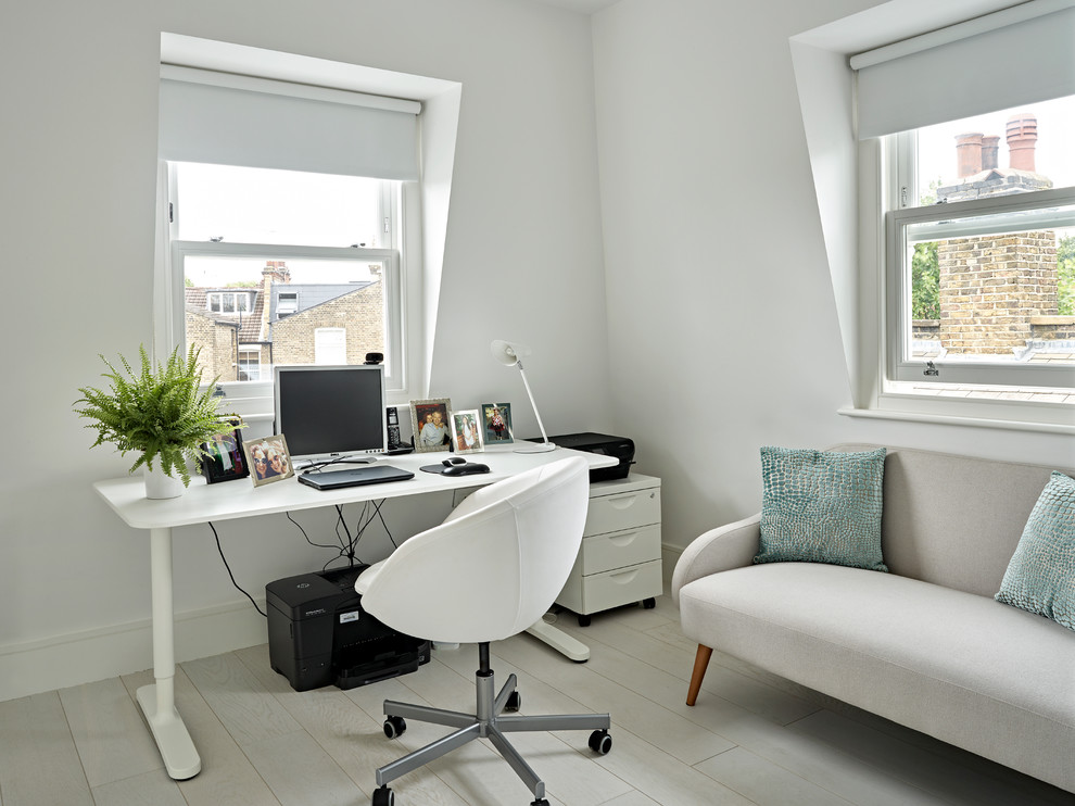 Mittelgroßes Modernes Arbeitszimmer mit weißer Wandfarbe, hellem Holzboden, freistehendem Schreibtisch und weißem Boden in London