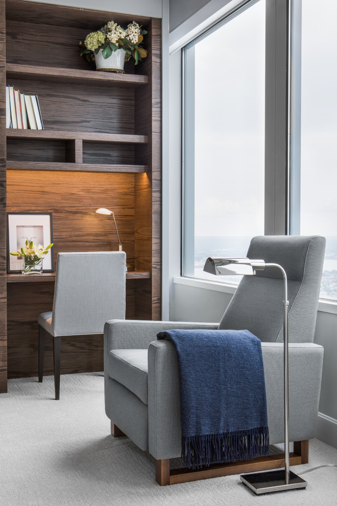 Ejemplo de despacho contemporáneo de tamaño medio sin chimenea con paredes grises, moqueta, escritorio empotrado y suelo beige