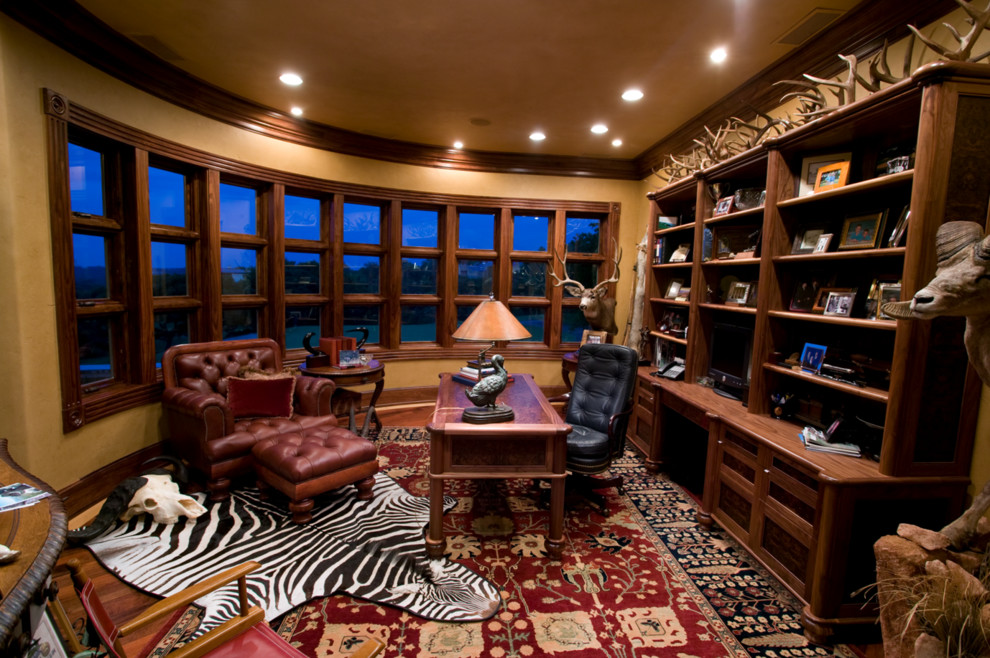 Huge tuscan freestanding desk dark wood floor study room photo in Dallas with beige walls and no fireplace