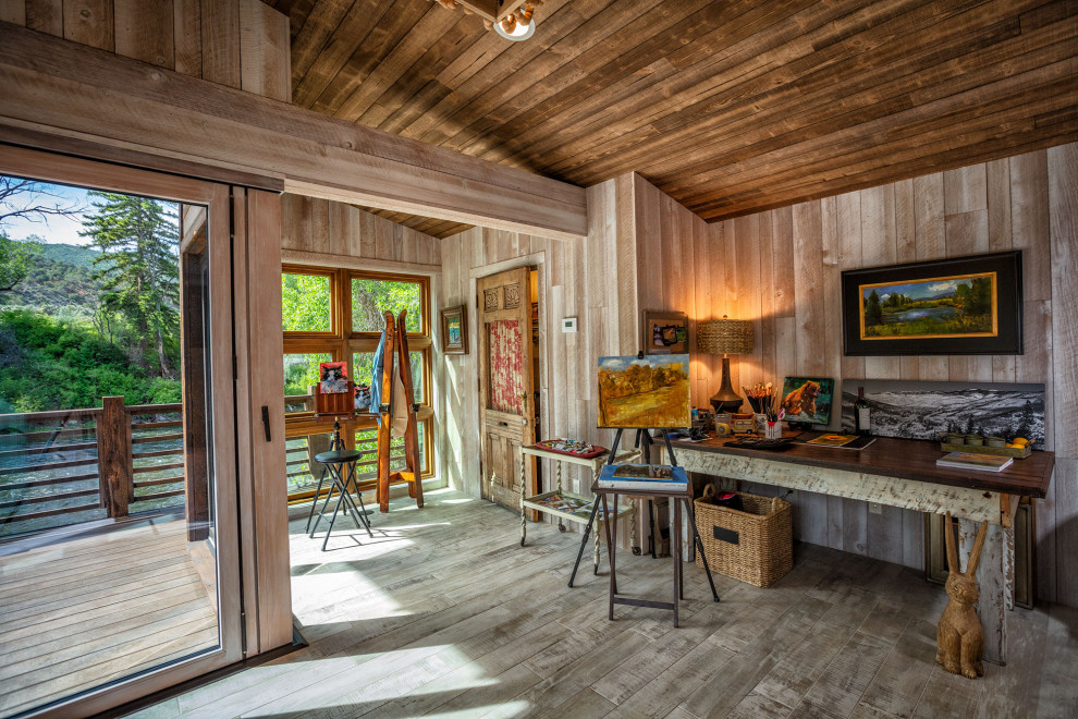 Réalisation d'un bureau chalet en bois avec un mur beige, un bureau indépendant, un sol gris, un plafond voûté et un plafond en bois.