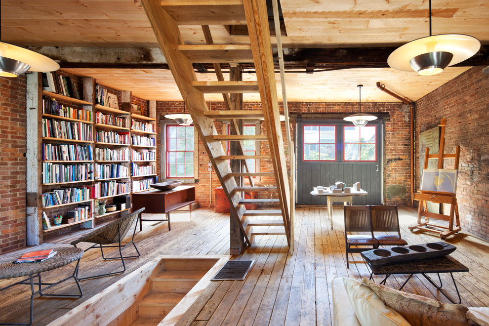 Industrial Arbeitszimmer mit Studio, roter Wandfarbe, braunem Holzboden und freistehendem Schreibtisch in New York