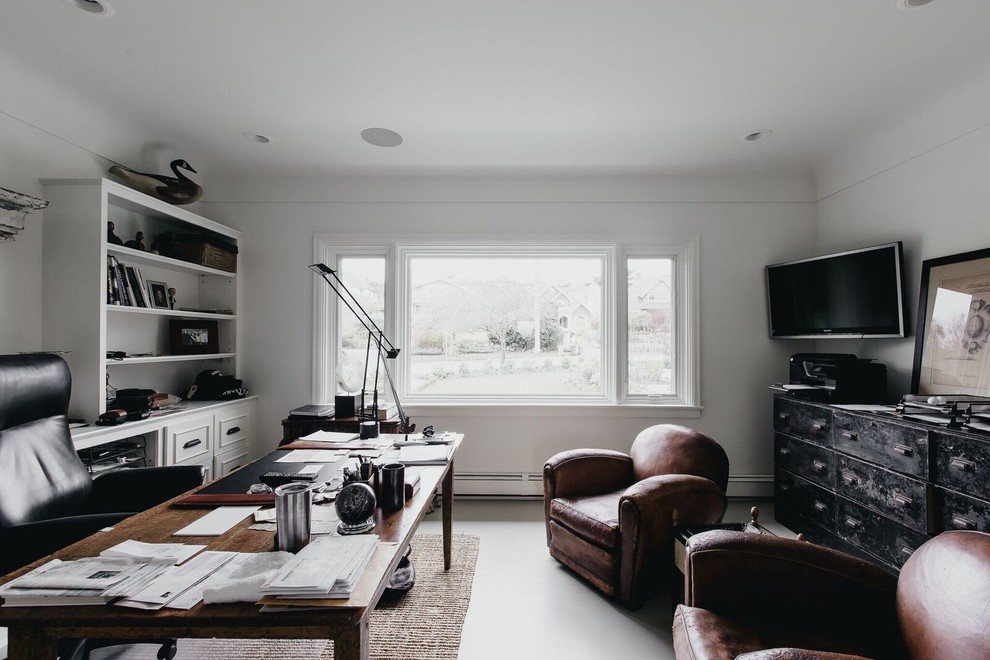 This is an example of a medium sized eclectic study in Vancouver with white walls, concrete flooring and a freestanding desk.