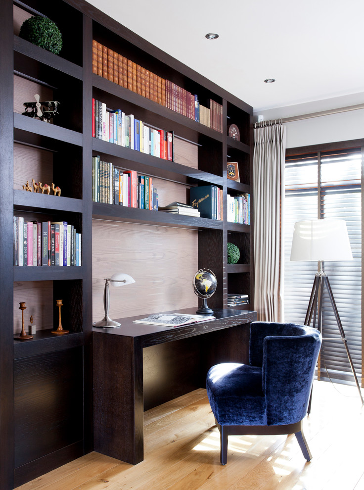 Diseño de despacho tradicional renovado con paredes grises, suelo de madera clara y escritorio empotrado