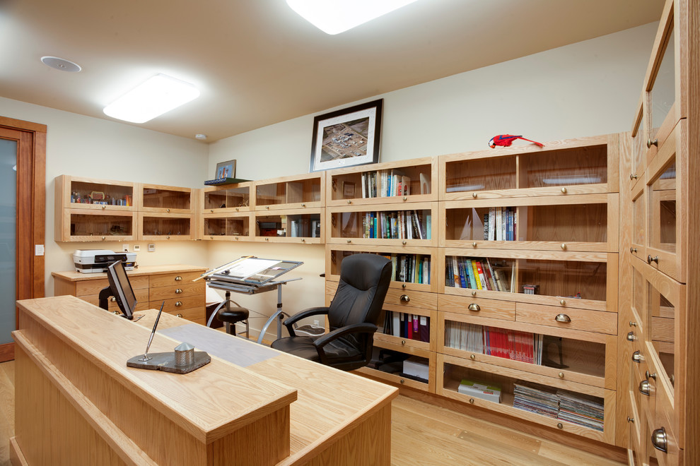 Idee per un ufficio minimal con pareti beige, parquet chiaro e scrivania autoportante