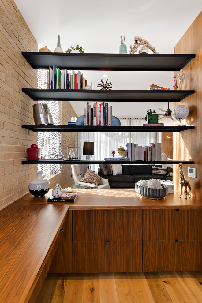 Inspiration för ett litet funkis hemmabibliotek, med beige väggar, ljust trägolv, ett inbyggt skrivbord och beiget golv