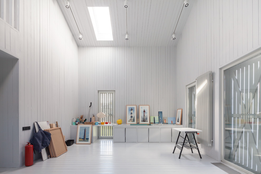 Источник вдохновения для домашнего уюта: домашняя мастерская в скандинавском стиле с белыми стенами, деревянным полом и отдельно стоящим рабочим столом