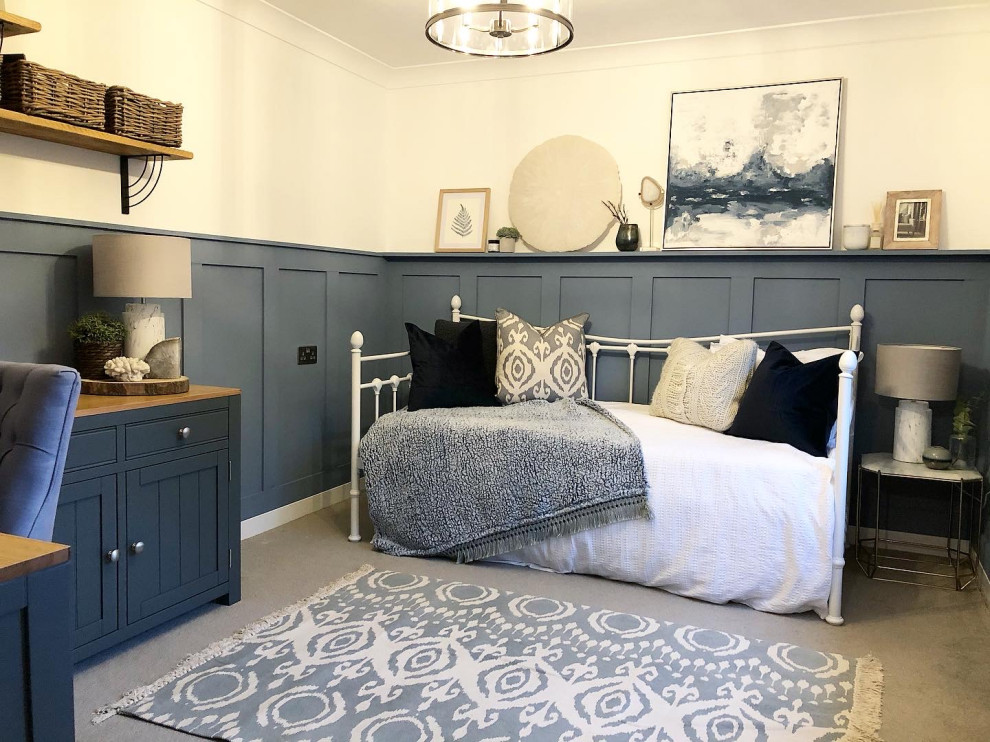 This is an example of a medium sized farmhouse home studio in Hampshire with blue walls, carpet, no fireplace, a freestanding desk and grey floors.