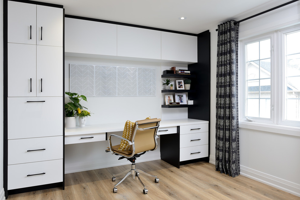 Großes Modernes Arbeitszimmer mit braunem Holzboden, braunem Boden, weißer Wandfarbe und Einbau-Schreibtisch in Toronto