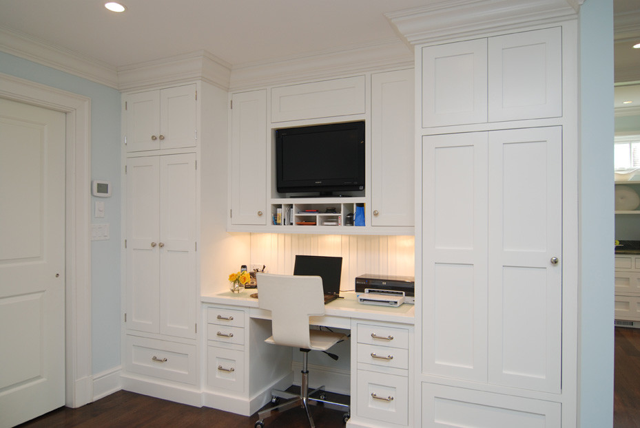 Inredning av ett modernt litet arbetsrum, med vita väggar, ett inbyggt skrivbord och mörkt trägolv