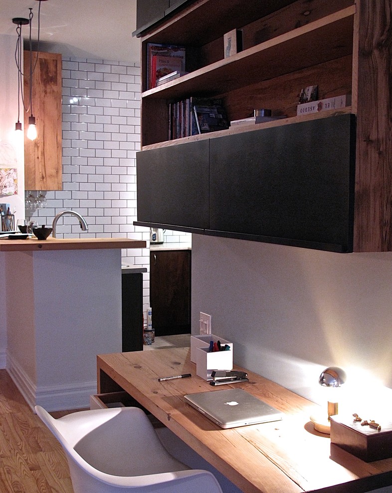 Photo of an urban home office in Montreal with blue walls, light hardwood flooring and a built-in desk.