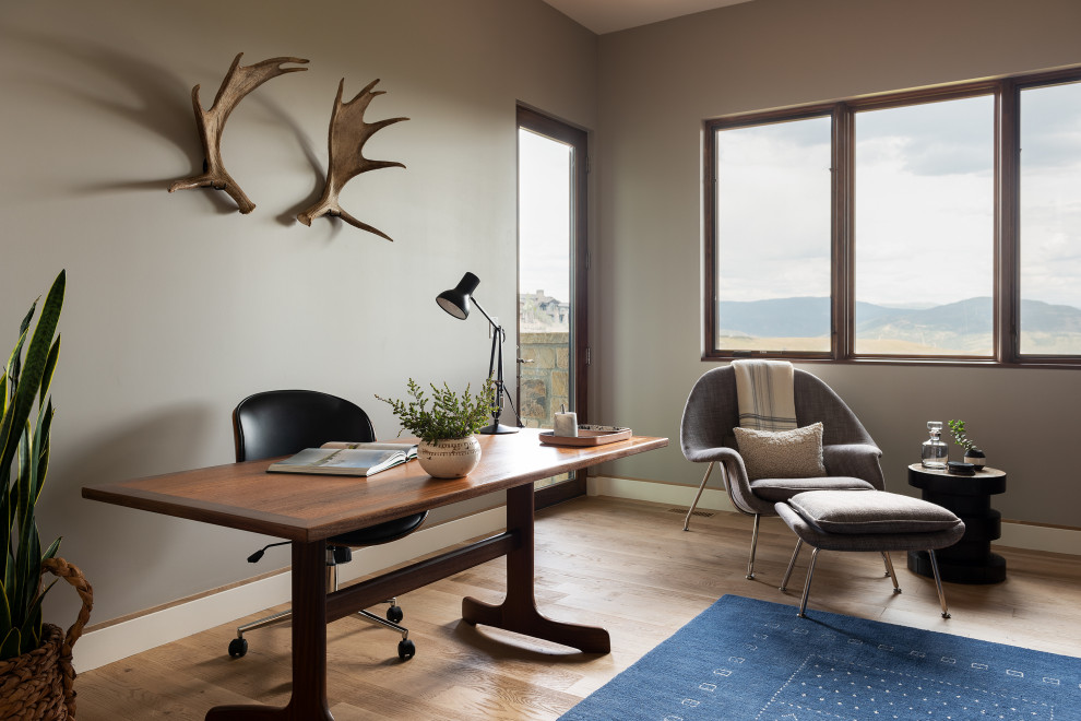 Inspiration för mellanstora rustika arbetsrum, med grå väggar, ett fristående skrivbord, brunt golv och mellanmörkt trägolv