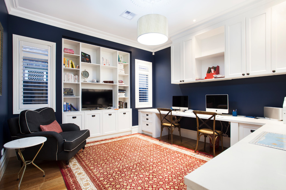 Großes Klassisches Arbeitszimmer ohne Kamin mit Arbeitsplatz, blauer Wandfarbe, braunem Holzboden und Einbau-Schreibtisch in Melbourne