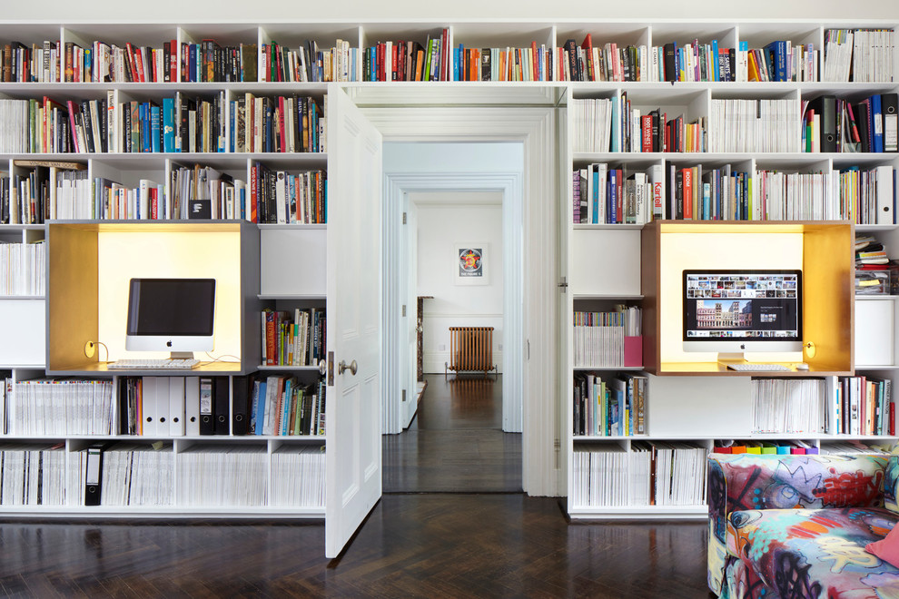 Idéer för att renovera ett stort funkis hemmabibliotek, med vita väggar, mörkt trägolv och ett inbyggt skrivbord