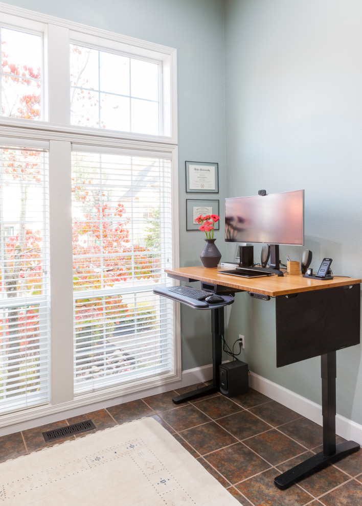 Ejemplo de despacho clásico renovado pequeño con biblioteca, paredes azules, suelo de pizarra, escritorio independiente y suelo multicolor