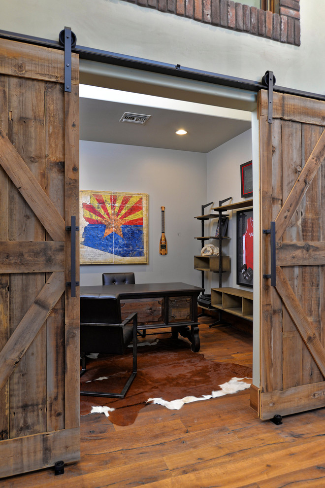 Idée de décoration pour un bureau chalet de taille moyenne avec un mur gris, un sol en bois brun et un bureau indépendant.