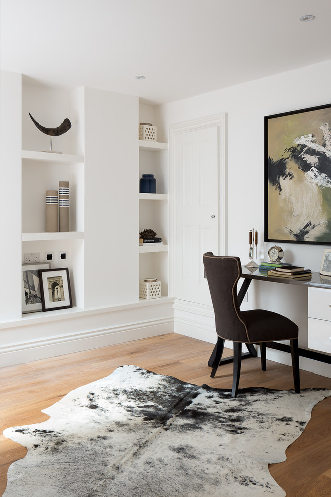 Modernes Arbeitszimmer ohne Kamin mit Arbeitsplatz, weißer Wandfarbe, hellem Holzboden und freistehendem Schreibtisch in London