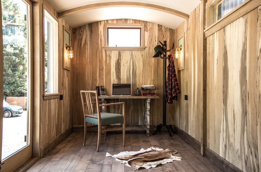 Diseño de despacho rural con suelo de madera oscura y escritorio independiente