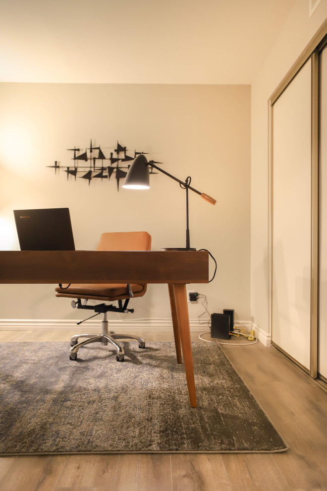 Immagine di un piccolo ufficio minimalista con pareti grigie, pavimento in laminato, scrivania autoportante e pavimento grigio