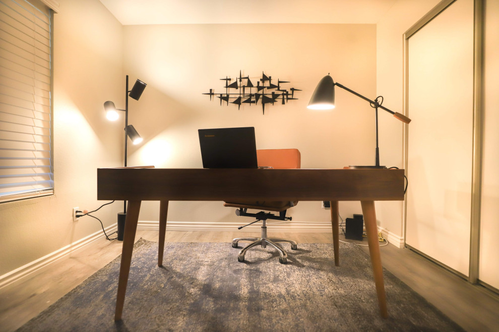 Kleines Modernes Arbeitszimmer mit Arbeitsplatz, grauer Wandfarbe, Laminat, freistehendem Schreibtisch und grauem Boden in Los Angeles
