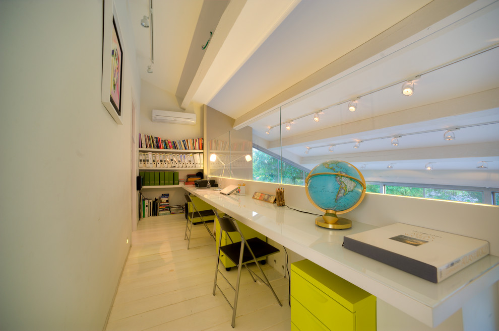 Idée de décoration pour un bureau design avec un mur blanc et un bureau intégré.