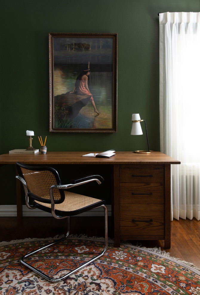 Esempio di uno studio tradizionale di medie dimensioni con libreria, pareti verdi, parquet scuro, scrivania autoportante e pavimento marrone