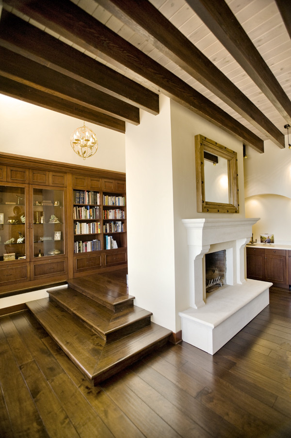 Cette photo montre un grand bureau éclectique avec une bibliothèque ou un coin lecture, un mur blanc, parquet foncé, une cheminée standard, un manteau de cheminée en bois, un bureau indépendant et un sol marron.