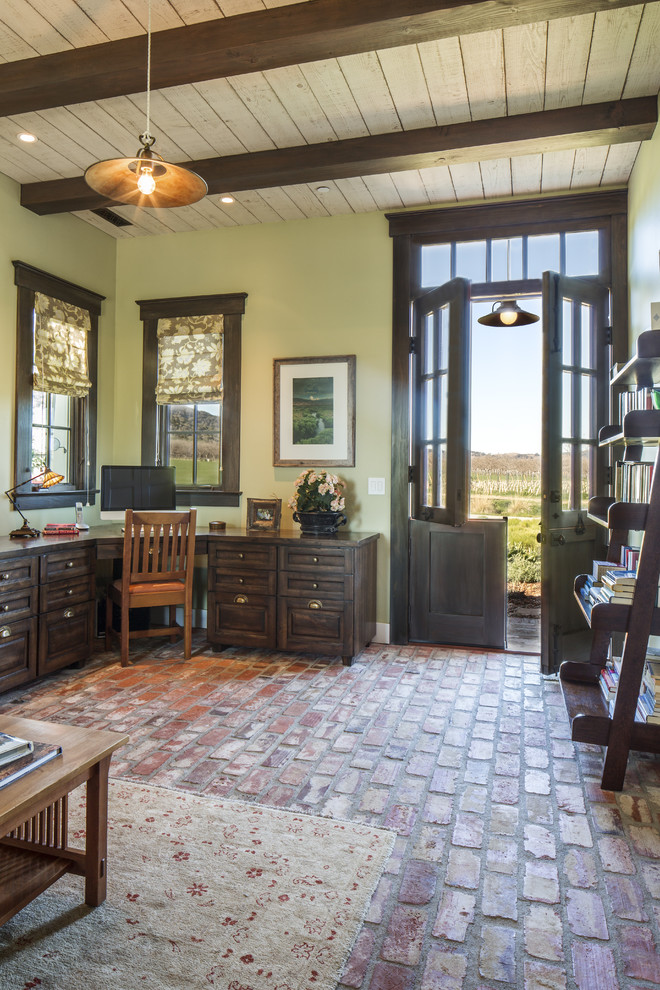 Large arts and crafts built-in desk brick floor home studio photo in Santa Barbara with green walls and no fireplace