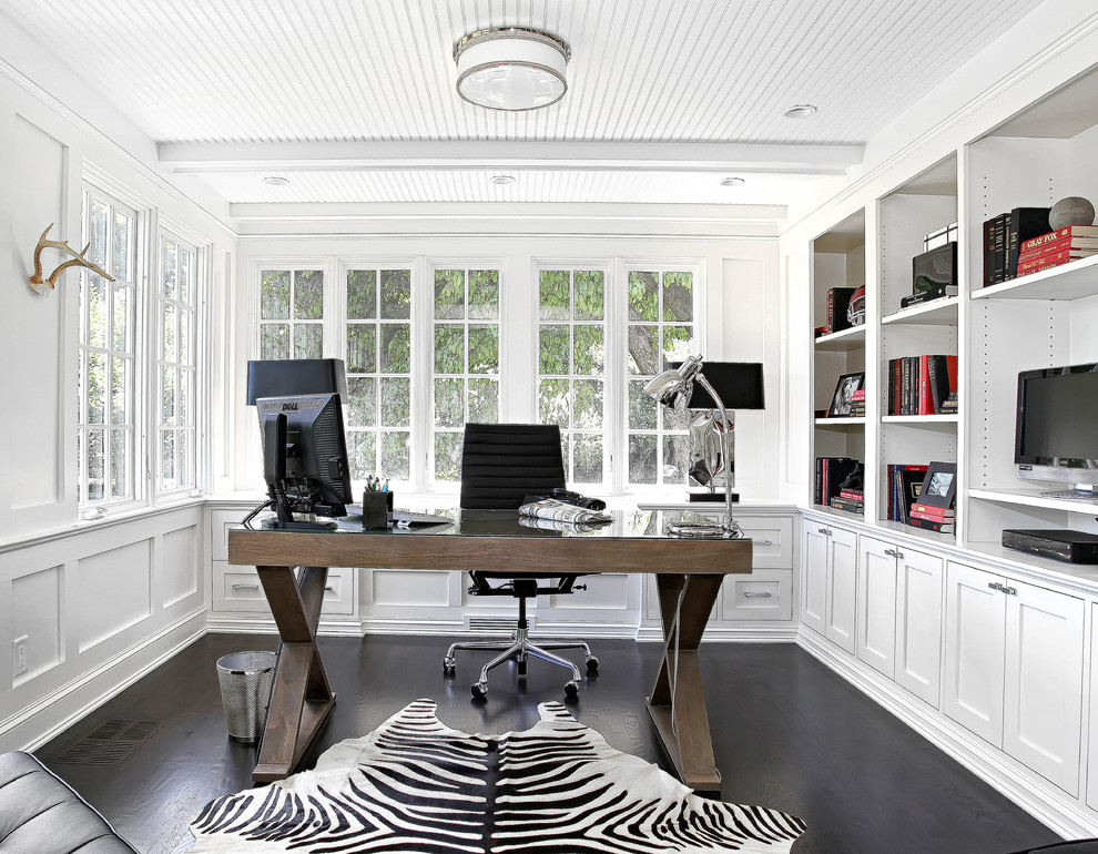 Bild på ett vintage arbetsrum, med vita väggar, mörkt trägolv, ett fristående skrivbord och svart golv