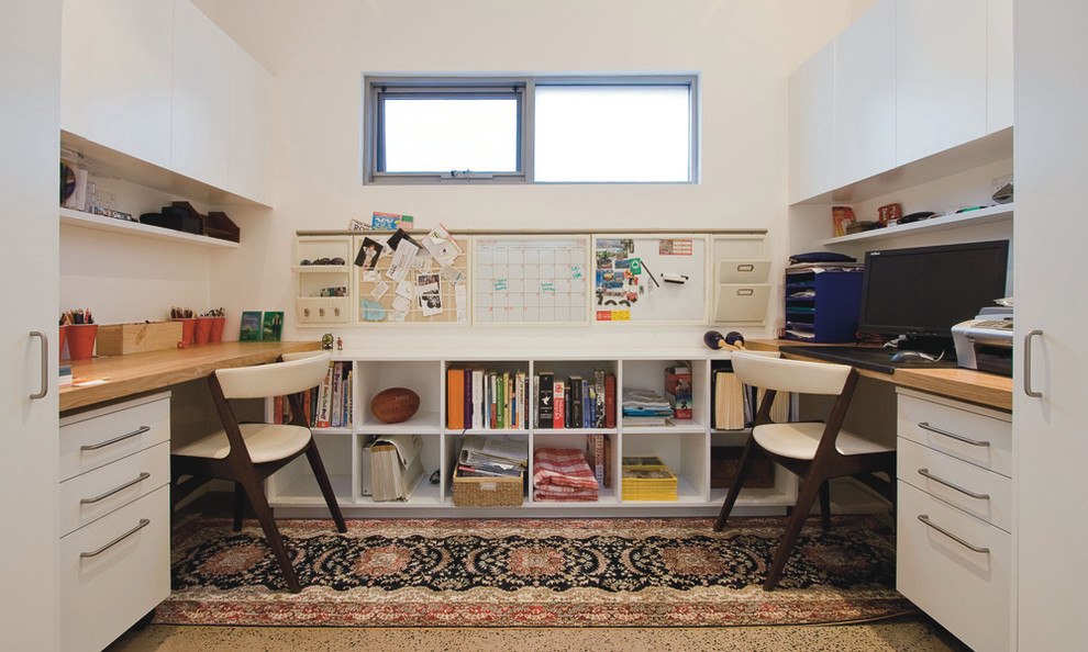 Modernes Arbeitszimmer mit weißer Wandfarbe und Einbau-Schreibtisch in Sydney
