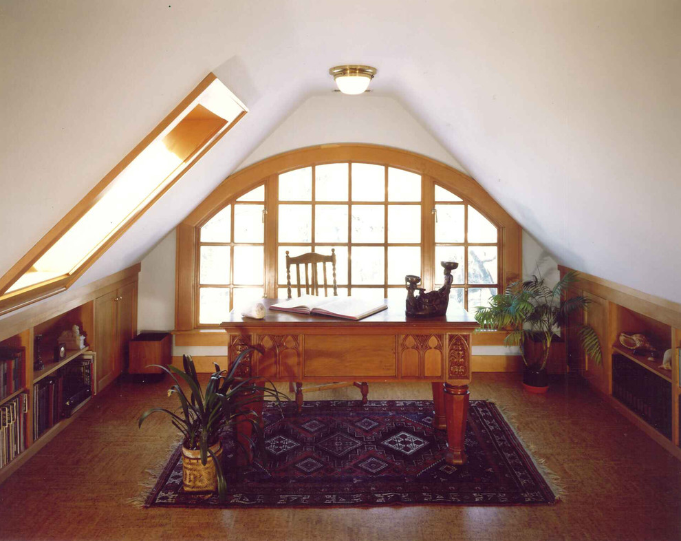 Inspiration för ett litet amerikanskt hemmabibliotek, med vita väggar, korkgolv och ett fristående skrivbord