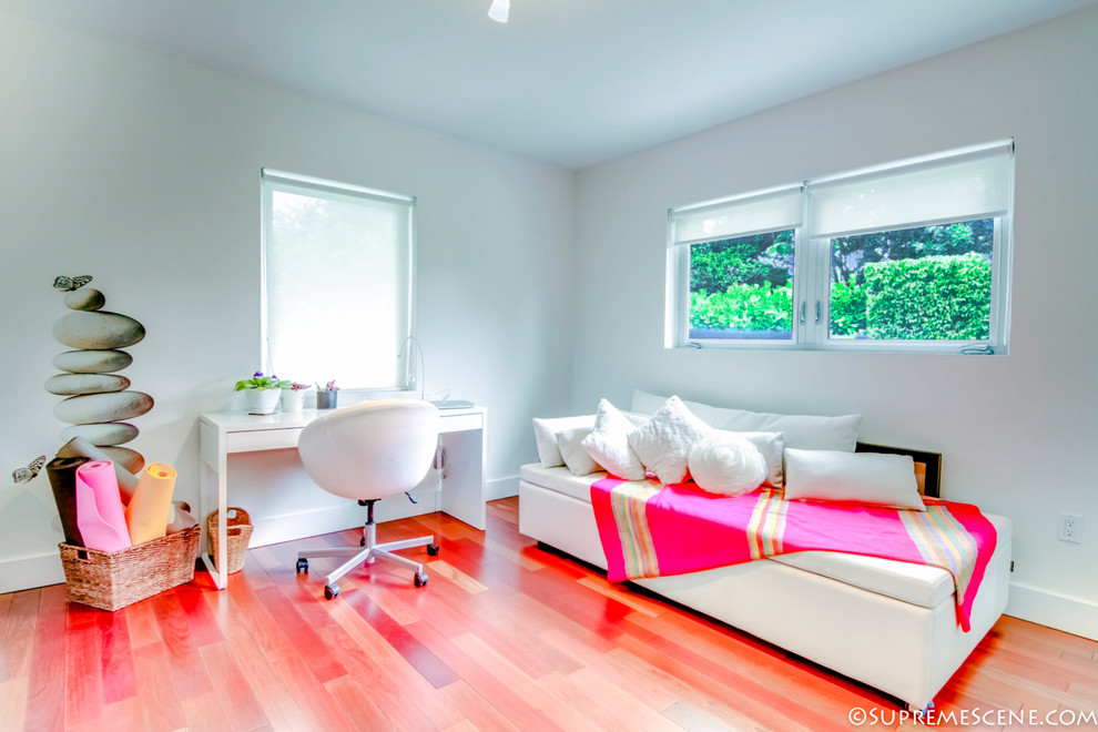 Esempio di uno studio tropicale con pareti bianche e pavimento in legno massello medio