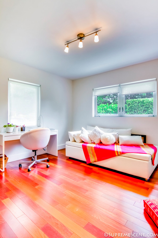 Modernes Arbeitszimmer mit weißer Wandfarbe und braunem Holzboden in Miami
