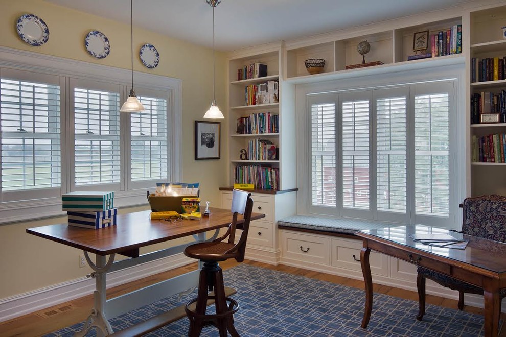 Inspiration för mellanstora lantliga hemmabibliotek, med beige väggar, ljust trägolv, ett fristående skrivbord och beiget golv