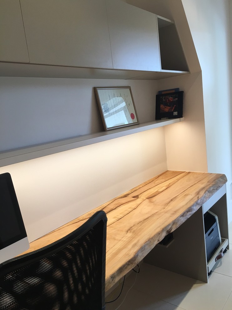 Foto de despacho contemporáneo pequeño sin chimenea con paredes blancas, suelo de baldosas de porcelana y escritorio empotrado