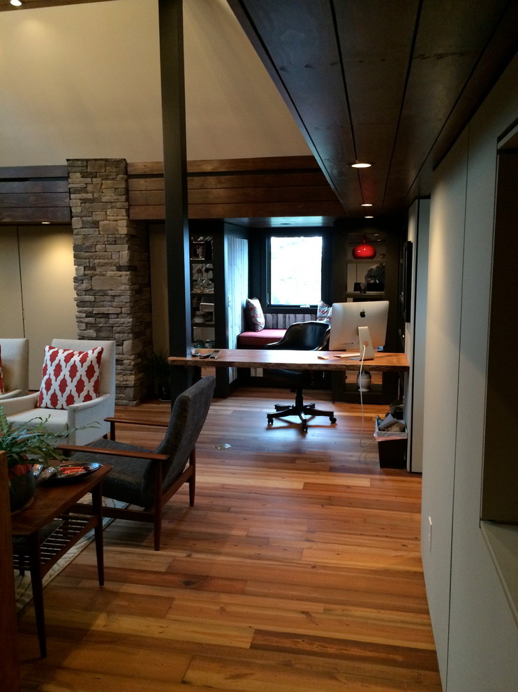Idéer för mellanstora funkis hemmabibliotek, med mellanmörkt trägolv och ett fristående skrivbord