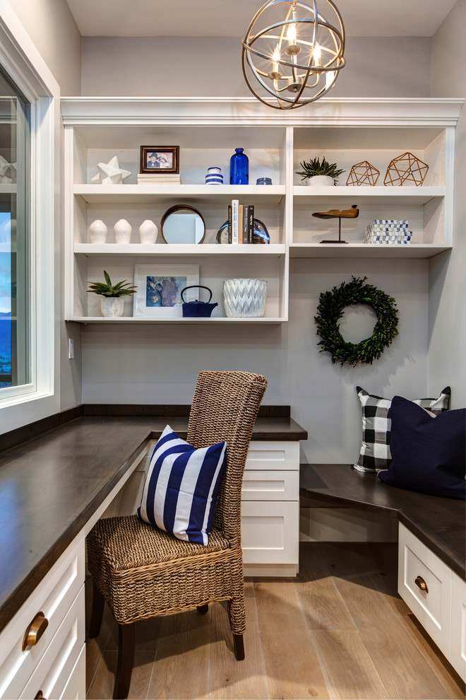 Ejemplo de despacho campestre de tamaño medio con paredes blancas, suelo de madera clara y escritorio empotrado