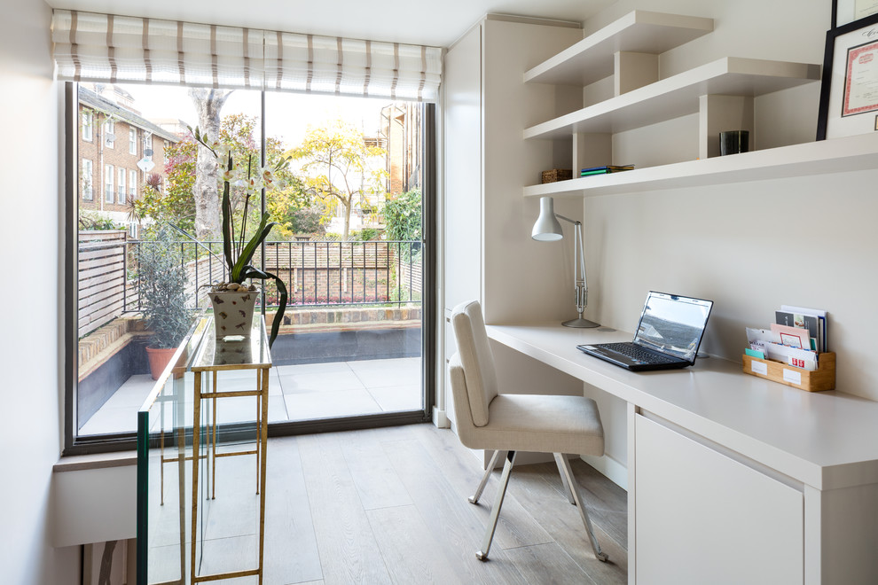 Mittelgroßes Modernes Arbeitszimmer ohne Kamin mit Arbeitsplatz, braunem Holzboden, Einbau-Schreibtisch und braunem Boden in London